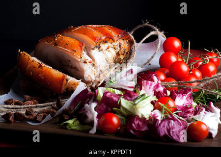 Zubereitet Schweinefleisch und Salat auf der Holzplatte. Foto. Stockfoto