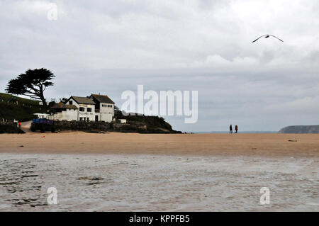 Ein Paar zu Fuß über den Strand, bei Ebbe, von der Insel von Bigbury-on-Sea, Devon, Großbritannien. Stockfoto