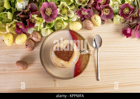 Kaffee mit Herzen und Blumen Ostern Dekoration auf Holztisch. Ansicht von oben Stockfoto