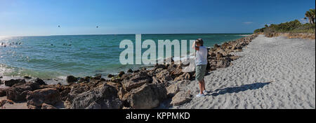 Frau mit Meerblick bei pelikane Angeln, Florida Beach Panoramablick Stockfoto
