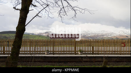 Llangower Bahnhof, Bala Lake Railway Station Name Board, den See und die Berge hinter, Schnee im Winter Snowdonia Szene Stockfoto