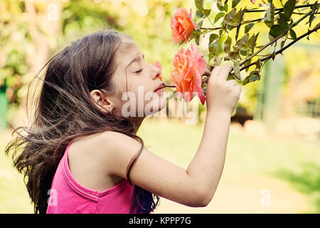 Kleines Mädchen duftende Rose Stockfoto