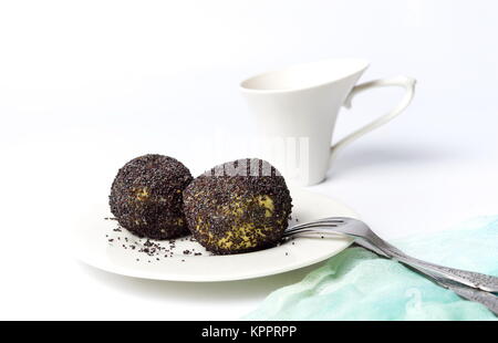 Knödel mit Mohn und Tasse Tee auf Weiß Stockfoto