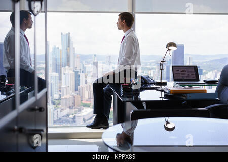 Business Person sitzt am Schreibtisch aus Office Fenster Stockfoto