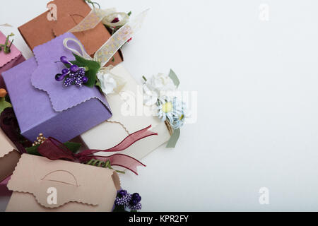Besondere Art der Geschenkboxen mit Band und Blumen auf weißem backgroung, Ansicht von oben Stockfoto