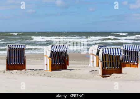 Liegestühle mit Sonnenschirm in Kolberg in Polen können an einem Sandstrand an der Küste der Ostsee gesehen werden. Stockfoto