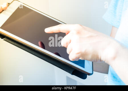 Hand, die digitale Tafel neben dem Fenster Stockfoto