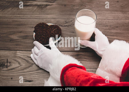 In der Nähe von Santa's Händen herauf Kekse und Milch, die Links in der Tabelle am Heiligabend Stockfoto