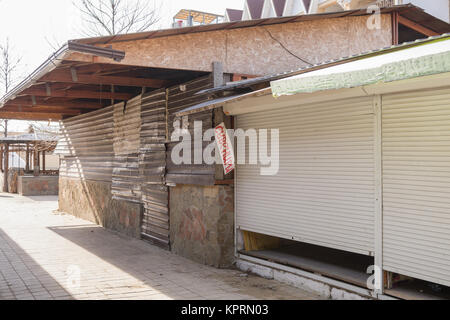 Geschlossenen Handel Pavillons und verschalten Metallosayding Gebäude ein Straßencafé auf einem einsamen Meer Straße Stockfoto