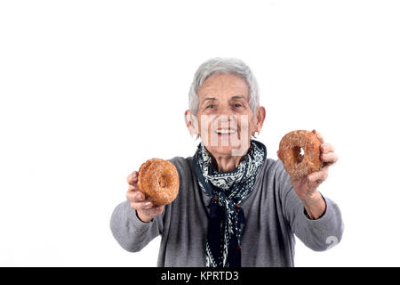 Ältere Frau essen Donut auf Weiß Stockfoto