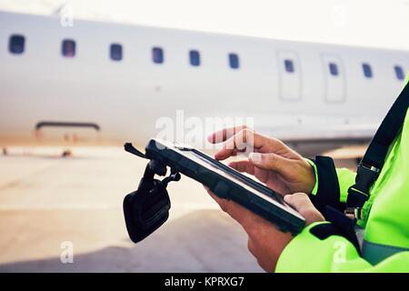 Moderne Technik am Flughafen. Mitglied des Bodenpersonals Vorbereitung der Passagier im Flugzeug vor dem Flug. Stockfoto