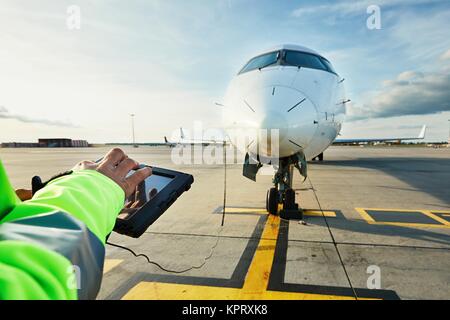 Moderne Technik am Flughafen. Mitglied des Bodenpersonals Vorbereitung der Passagier im Flugzeug vor dem Flug. Stockfoto