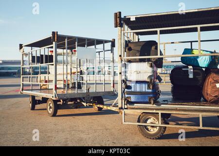 Karren mit Gepäck. Einem langen sonnigen Tag am Flughafen. Stockfoto