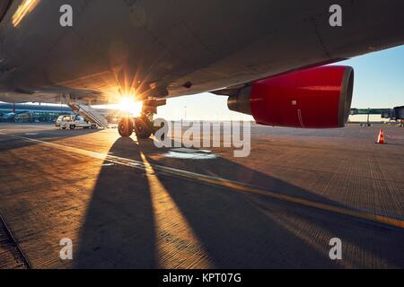 Das Fahrwerk des Flugzeugs. Sonnenuntergang am Flughafen. Stockfoto