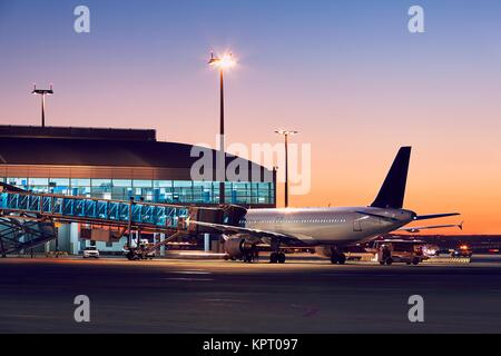 Vorbereitung des Flugzeuges vor dem Flug. Flughafen in der bunten Sonnenuntergang. Stockfoto