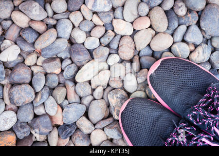 Laufschuhe im Hausgarten auf Kieselsteinen, Fotoarchiv Stockfoto