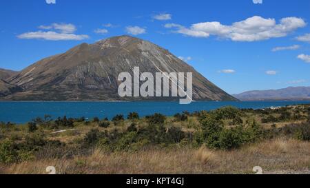 Türkisfarbene Wasser des Lake Ohau. Wolken über einem Gipfel des Ben Ohau Range. Landschaft in Neuseeland. Stockfoto