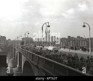 1950er Jahre, an die Arbeit gehen, historische Bild, pendler am frühen Morgen Überqueren einer viel befahrenen London Bridge, London, England, UK. Stockfoto