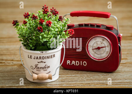Künstliche Blumen, rot vintage Radio auf hölzernen Hintergrund Stockfoto