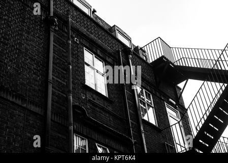 Schwarz-weiß Bild von einer externen Metalltreppe für Notausgänge aus einem Gebäude verwendet Stockfoto