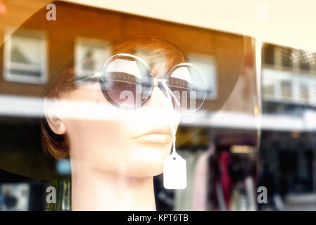 Mannequin Modell mit Sonnenbrille und ein Sommer Hut starrt aus einem Schaufenster mit niemand Stockfoto