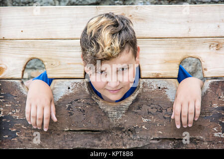 Jungen kaukasischen Jungen in mittelalterlichen Pranger. Elend Thema. Strafe Gerät. Stockfoto