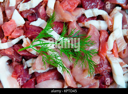 Ein Zweig Dill liegt auf der zerlegtes Fleisch. Das Kochen. Stockfoto