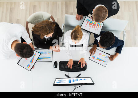 Geschäftsleute, die sich auf Graphen im Büro Stockfoto