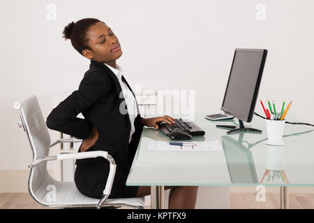 Geschäftsfrau leiden unter Rückenschmerzen im Büro Stockfoto