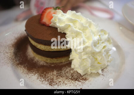 Geschichtete Pfannkuchen und Mousse au Chocolat mit Erdbeeren und Sahne Stockfoto