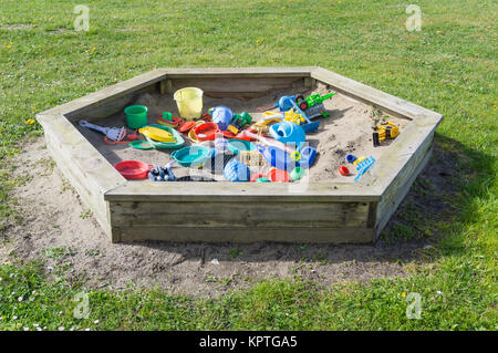 Sandkasten im Garten mit viel Spielzeug für Kinder Stockfoto