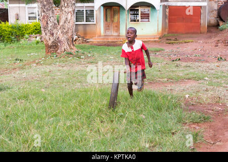 Eine ugandische Kind Dreht ein Rad Reifen. Stockfoto