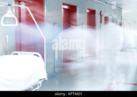 Flur im Krankenhaus mit unscharfem Arzt in Helvetica und Heben rot Stockfoto