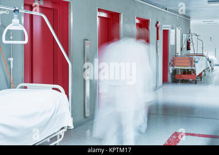 Flur im Krankenhaus mit unscharfem Arzt in Helvetica und Heben rot Stockfoto