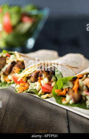 BBQ Chicken mit frischen Salat Tortilla wraps auf rustikalen Hintergrund Stockfoto