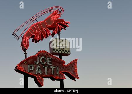 November 2017, Pensacola Beach Florida, Joe Patti Seafood Restaurant Neon beleuchtete Schild vor Sonnenaufgang. Stockfoto