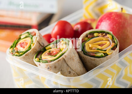 Schinken und Käse hüllt in Lunch-Box mit Apfel und Tomaten Stockfoto