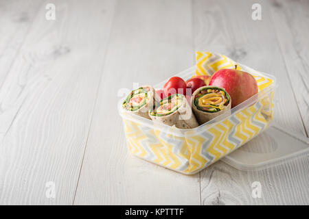 Schinken und Käse hüllt in Lunch-Box mit Apfel und Tomaten Stockfoto