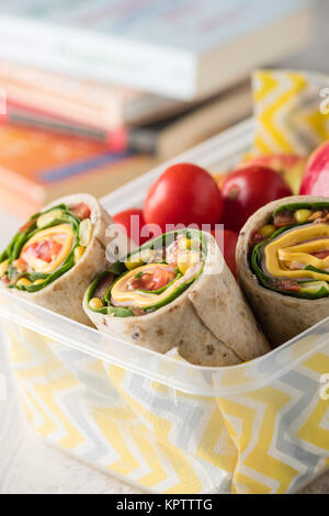 Schinken und Käse hüllt in Lunch-Box mit Apfel und Tomaten Stockfoto