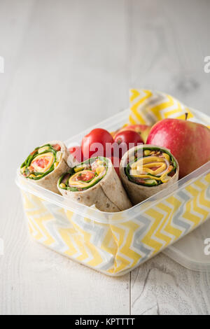 Schinken und Käse hüllt in Lunch-Box mit Apfel und Tomaten Stockfoto