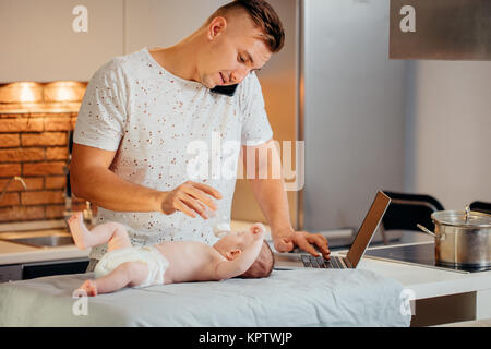 Mann von zu Hause aus zu arbeiten und die Pflege des Babys Stockfoto