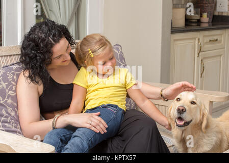 Mutter und Tochter mit Golden Retriever auf der Veranda Stockfoto