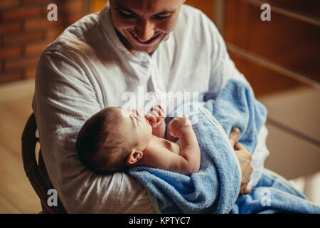 Mann an Schreibtisch zu Hause arbeiten mit Laptop, die niedlichen Babys, auf Bildschirm Stockfoto