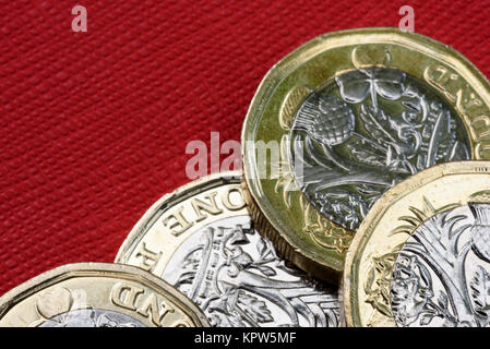 Neuen glänzenden UK Pound Münze Währung von Silber und Gold auf rotem Hintergrund. Münzen sind so konzipiert, dass sie die Fälschung der Englischen Geld zu stoppen Stockfoto