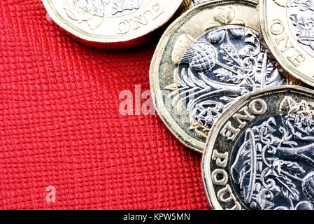 Neuen glänzenden UK Pound Münze Währung von Silber und Gold auf rotem Hintergrund. Münzen sind so konzipiert, dass sie die Fälschung der Englischen Geld zu stoppen Stockfoto