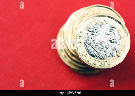 Neuen glänzenden UK Pound Münze Währung von Silber und Gold auf rotem Hintergrund. Münzen sind so konzipiert, dass sie die Fälschung der Englischen Geld zu stoppen Stockfoto