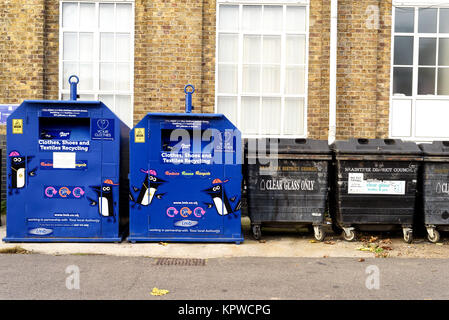 Blau und Schwarz recycling Bins für recycelte Tücher und Flaschen, Essex, England mit niemand Stockfoto