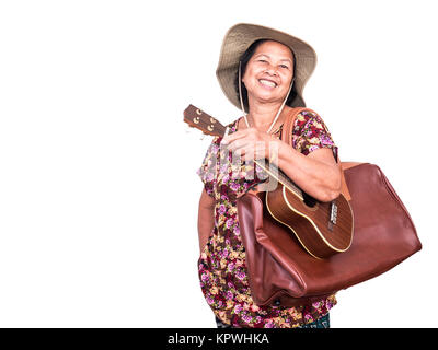 Asiatische bekommt Frau lächelnd, während die Ukulele und Big Brown Bag auf weißem Hintergrund mit Freistellungspfad Stockfoto