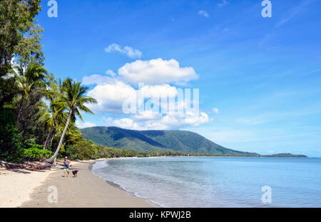 Mann, der seinen Hund an der malerischen Kewarra Beach, einem beliebten Vorort der nördlichen Strände von Cairns, Far North Queensland, FNQ, QLD, Australien Stockfoto