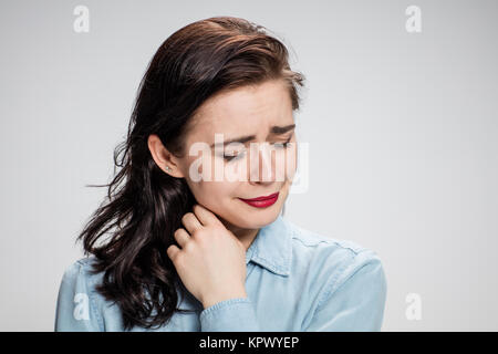 Das Porträt einer weinenden jungen einsame Frau auf grau Stockfoto